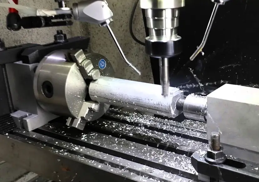 An image of a 4-axis CNC milling machine performing precision machining on a cylindrical metal workpiece 