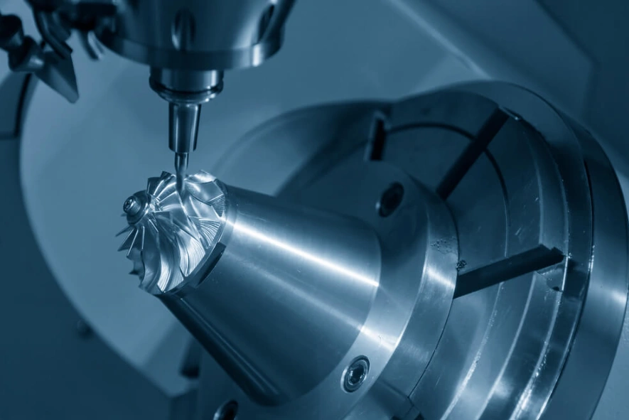 A close-up of a 5-axis CNC machining process manufacturing an intricate component at a slanted angle