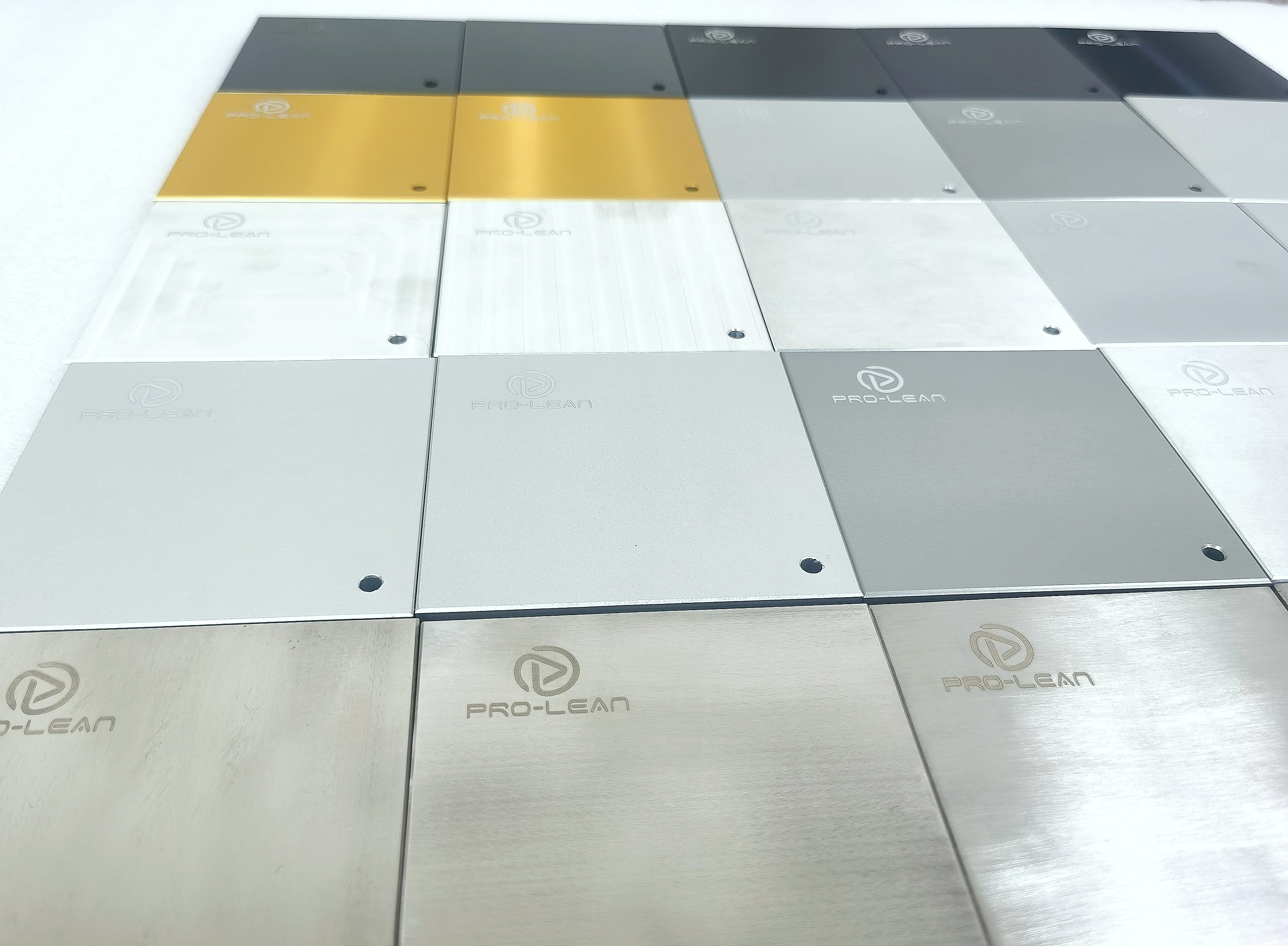 A row of metal test pieces showing different surface finishes from matte to reflective