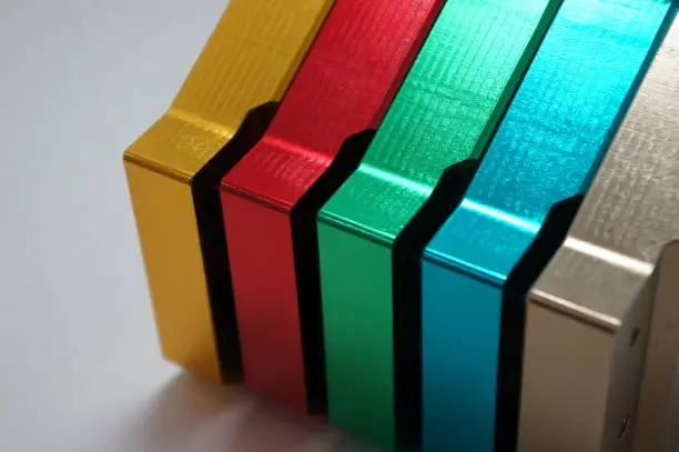 Close-up of stacked metallic blocks in gold, red, green, blue, and silver.