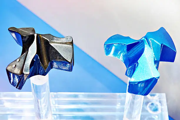 A side-by-side comparison of industrial components: a Type II matte grey finish for wear resistance and a Type III vibrant blue finish for aesthetics.