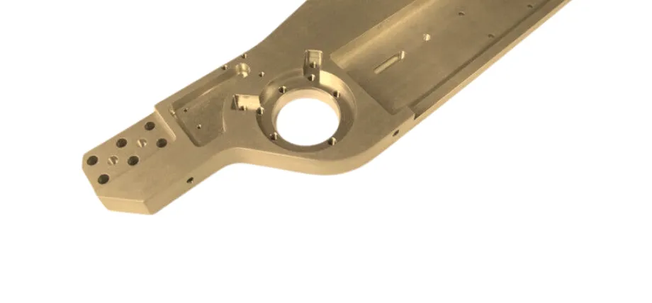 A gold-toned alodine coated complex machined aluminum component with various bore holes and precise milled channels.