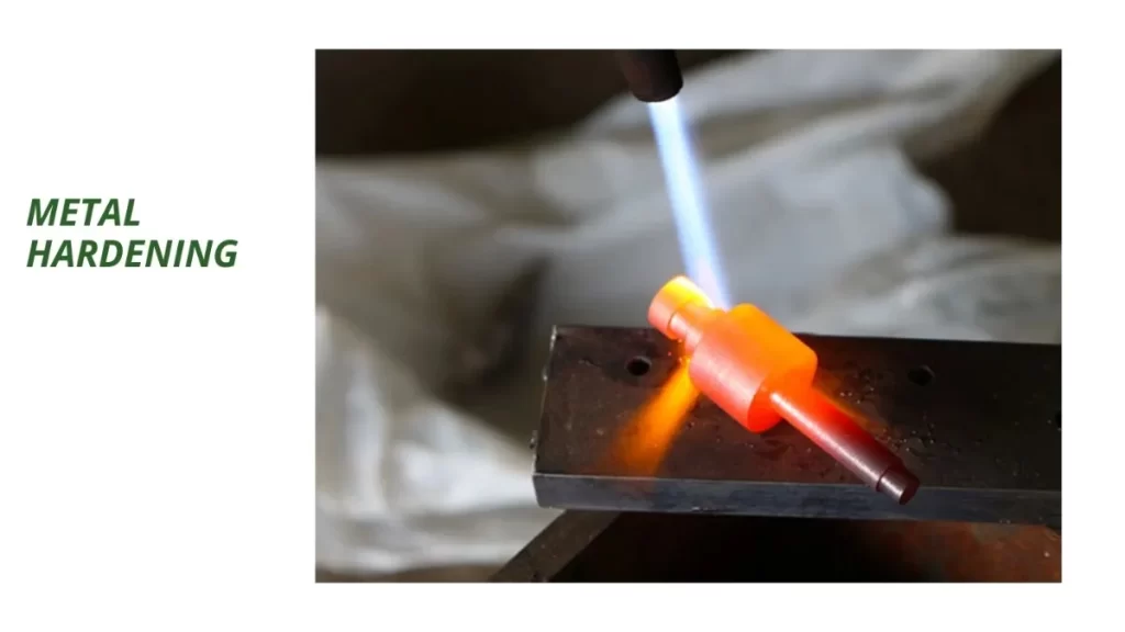 Close-up of a person performing metal hardening on a heated part.