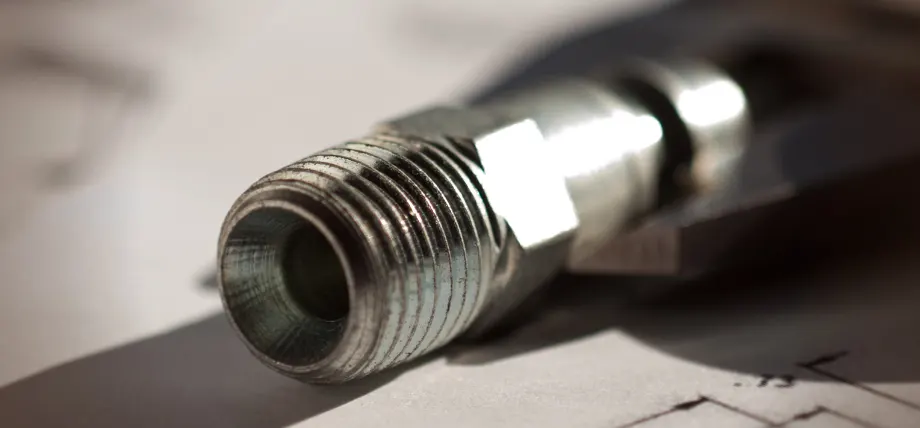 metal piece with large threads on a drawing sheet