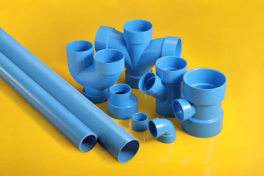 Blue plastic pipes and fittings on a yellow background.