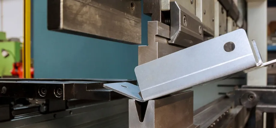 Press brake performing air bending on a powder-coated metal bracket with pre-punched holes during precision sheet metal fabrication.