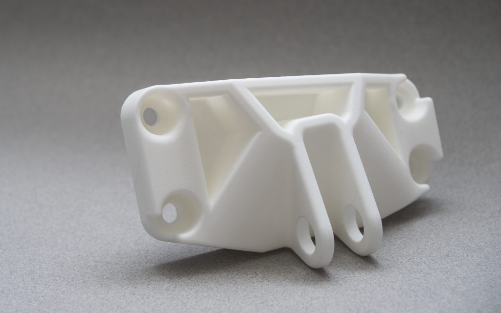 White machined nylon (PA) brackets and spacers after CNC machining