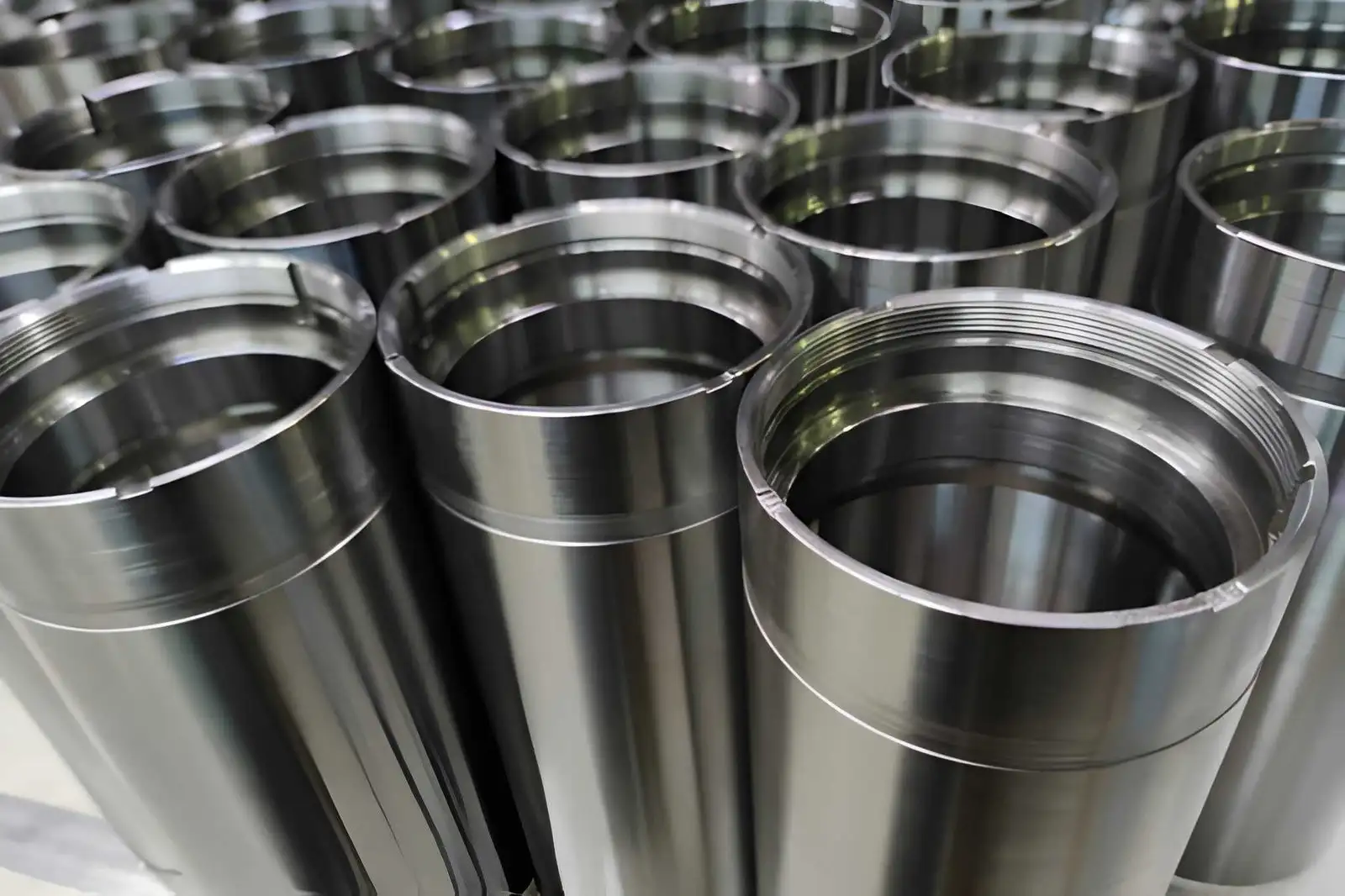 A batch of stainless steel tubular machined parts standing upright after passivation, showing a clean matte surface