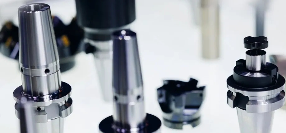 An array of precision-machined CNC tool holders with smooth, reflective industrial surface finishes.