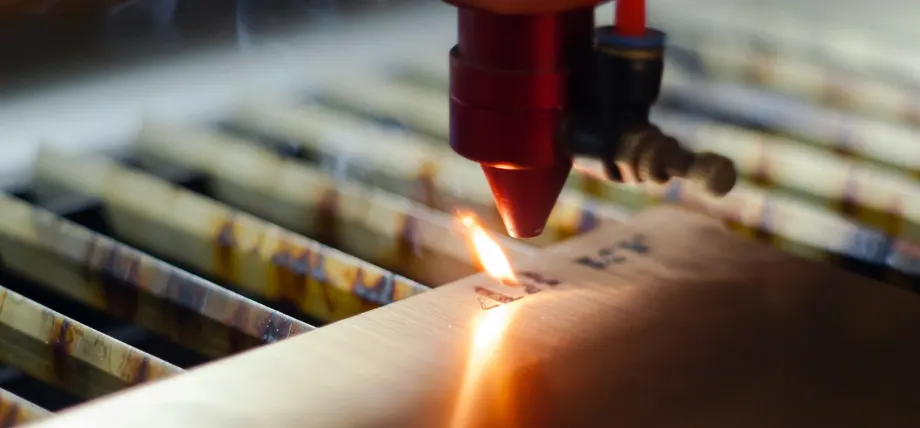 Laser engraving tool with black marks on wood and flame; engraving process