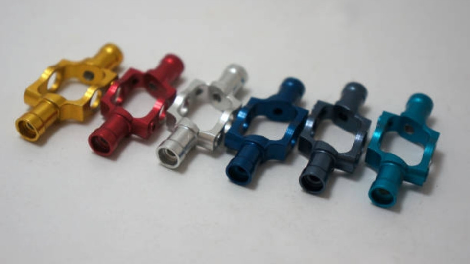 Six anodized steel parts with different colors