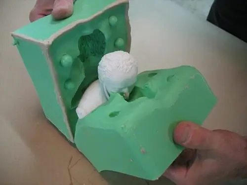 An image showing close up view of opening green colored two part mold. 