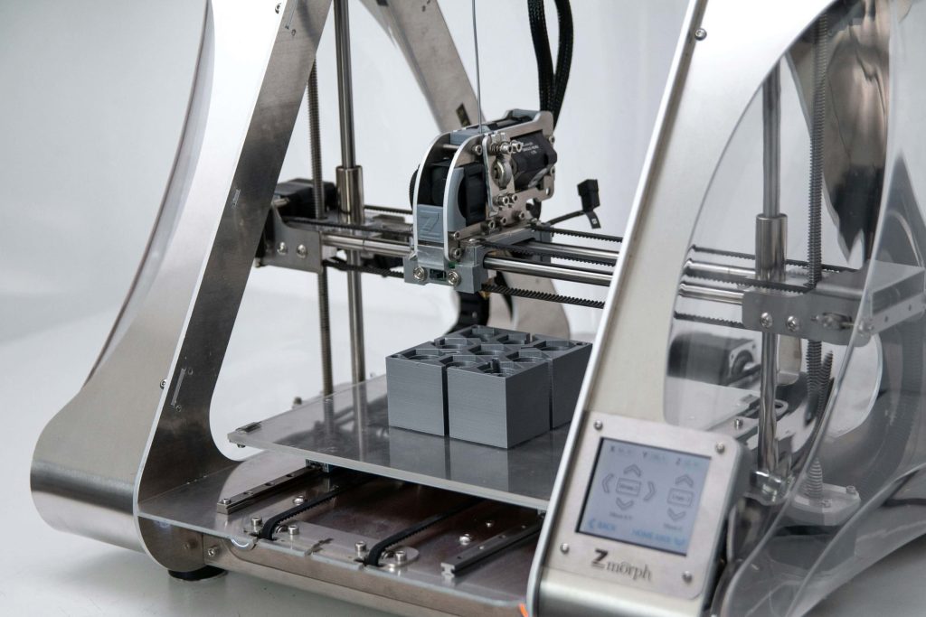 A silver 3D printer resting on a surface 