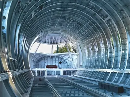 A section of the inside of an airplane’s fuselage showing interconnected metallic frames