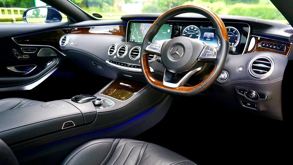 Luxury car interior showcasing premium dashboard and steering design for comfort and style.