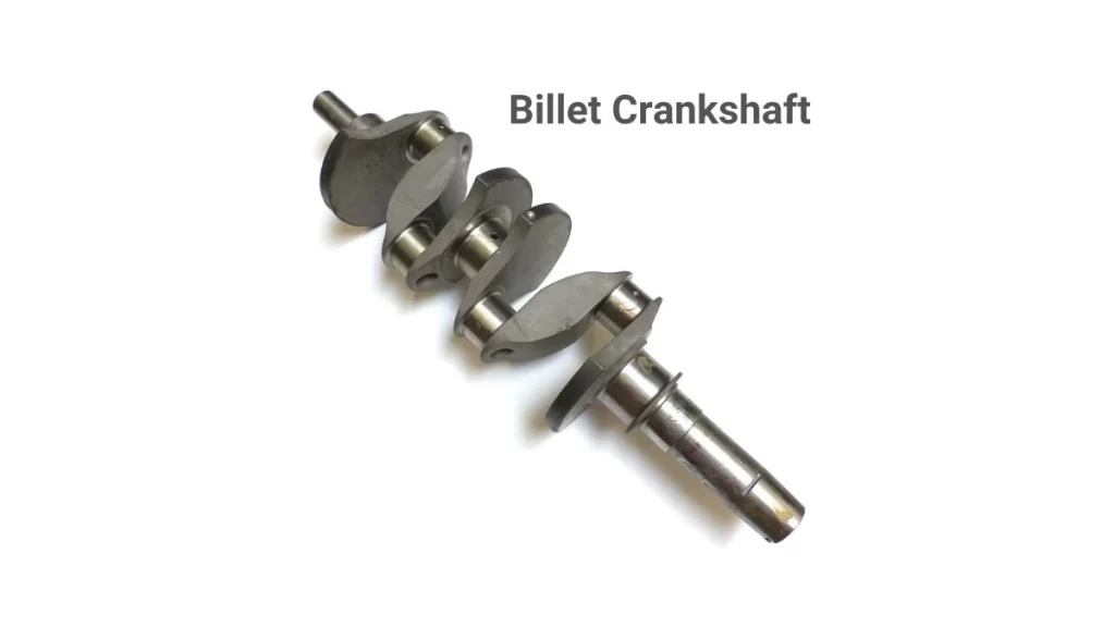 The image shows a billet crankshaft, crafted from a solid block of metal. The crankshaft is depicted with precise clean lines.