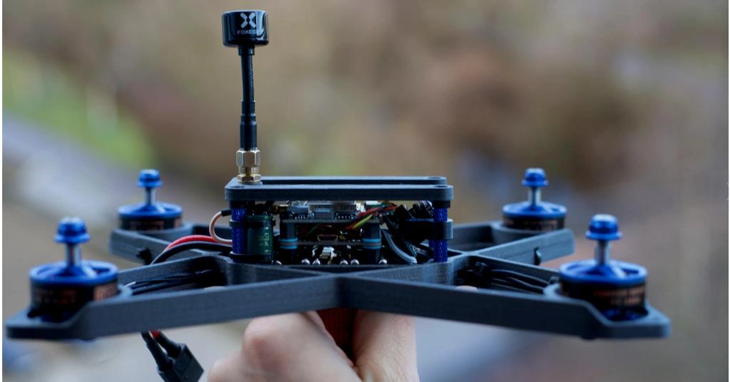 A close-up view of the drone housing ready to assemble with other components, holding it by a hand