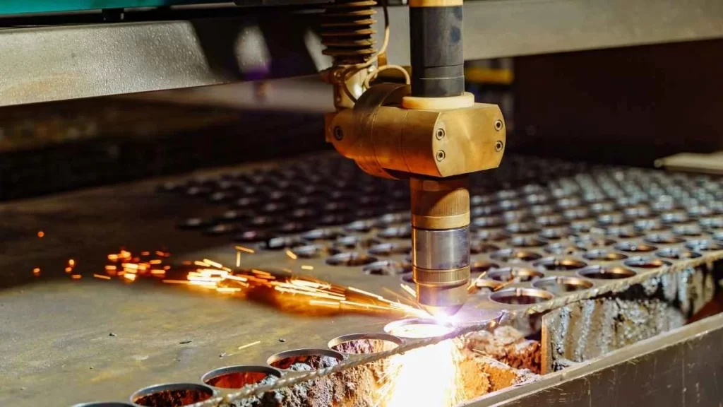 The image depicts a plasma-cutting machine creating holes in a metal sheet. The high-temperature plasma arc is used to precisely cut circular holes in the material, with visible sparks.