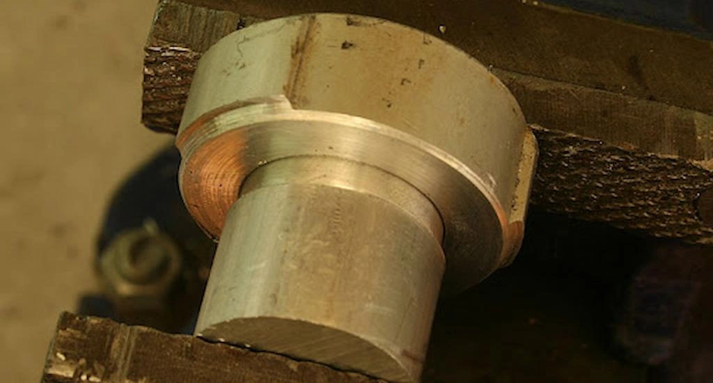 A mechanical vice pressuring the shaft into hole for press fitting.