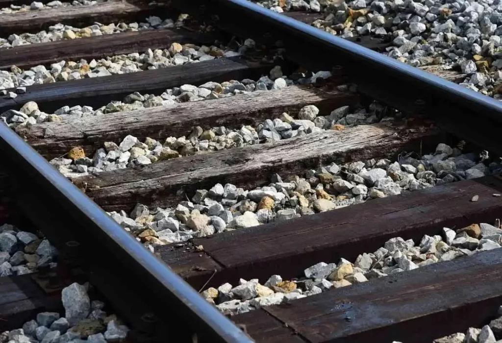 A closeup image of a rail track with wooden sleepers