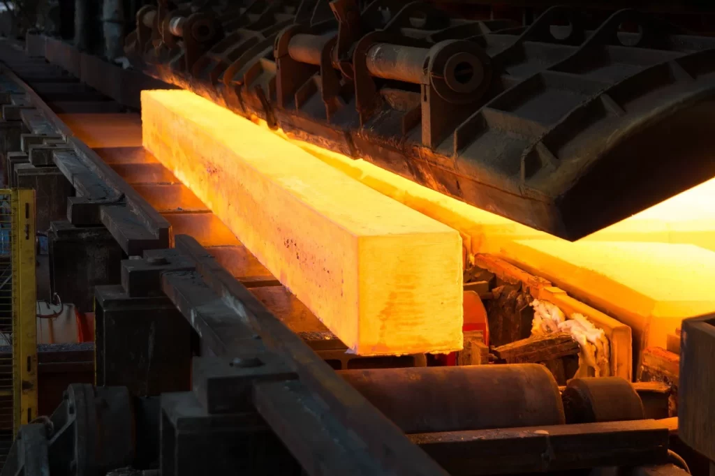 Glowing metal block undergoing heat treatment in an industrial annealing process for improved strength and flexibility.