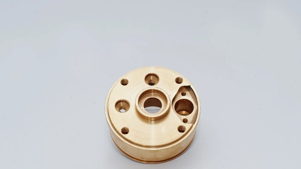 An automotive part with precisely tapped holes, showcasing clean and accurate threading on a metallic surface.