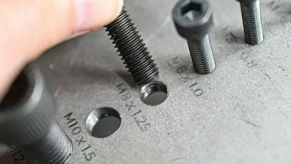 The image shows a tapped hole, where internal threads are cut to allow a screw to be screwed in.