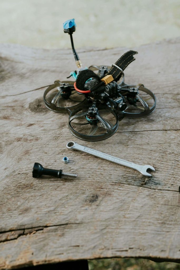 A small DIY drone, spanner, bolt, and nut on a table