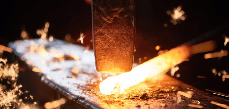 Forging process with hammer striking heated metal, emphasizing the role of annealing in creating strong and durable components.