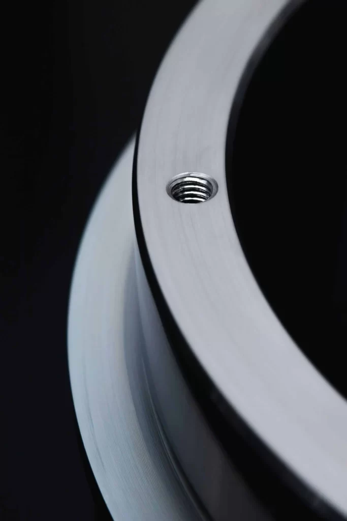 a section of a circular metallic part showing one threaded hole on the face 