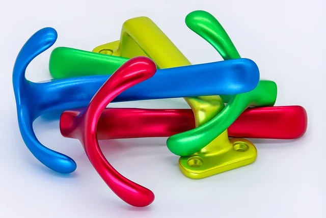 Four anodized aluminum parts with hook-like appearances of colors pink, blue, green, and yellow