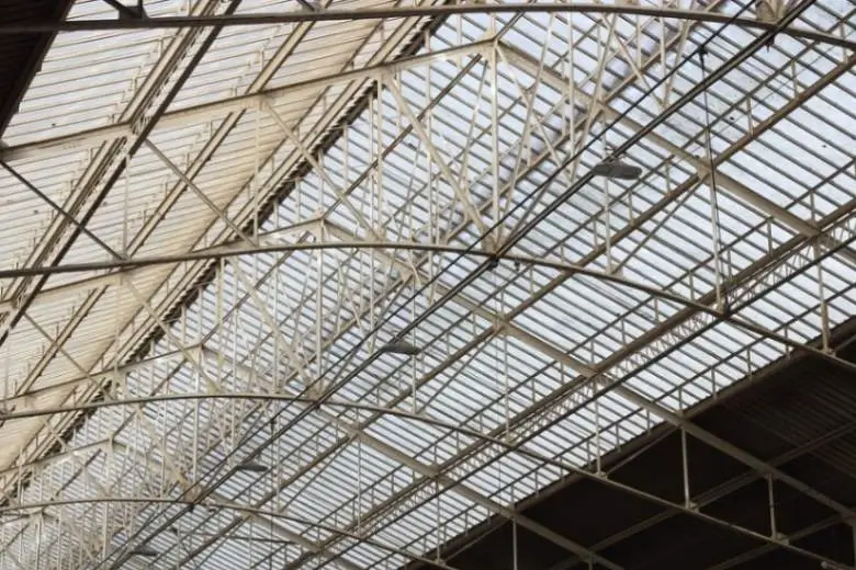 Metallic roof trusses comprising curved horizontal and straight vertical members