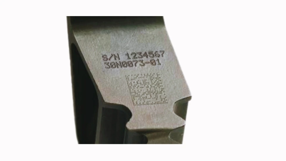 The Image showcases a titanium aircraft part with a laser-marked design. It displays clear, high-contrast markings on the surface for identification