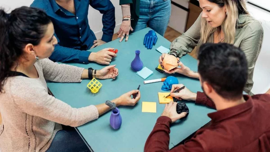 An Image of a team of professionals in a meeting. It refers to discussing material properties and post-finishing processes as part of a project evaluation to validate high-quality outputs.