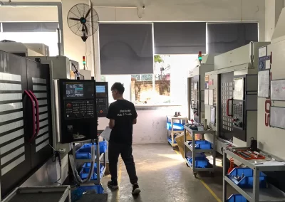 In the CNC machining workshop, a worker is preparing to operate the machine.