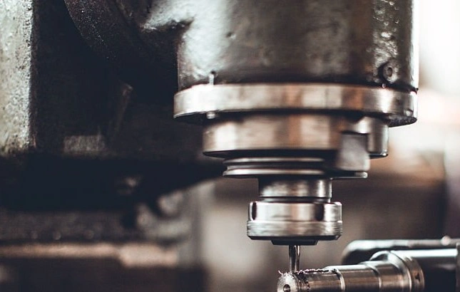 A high-speed drilling machine drilling a hole in a cylindrical metal workpiece