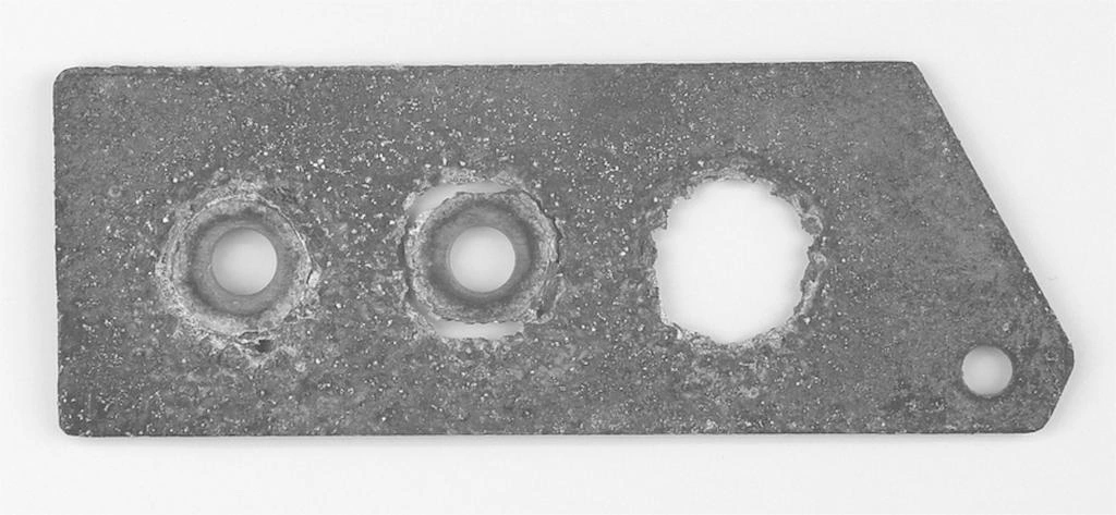 A magnesium alloy part with three holes, corrosion and material degradation on the surface and the hole’s cross-section 