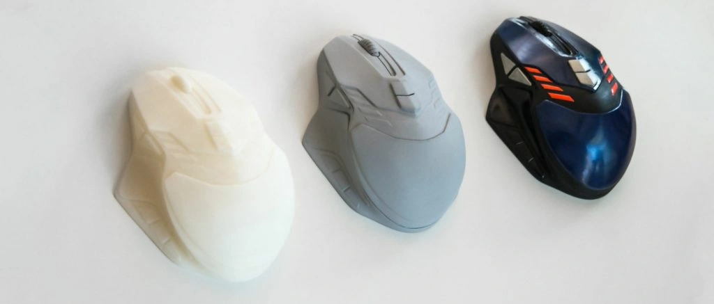 Three prototypes for computer mouse enclosures in white, gray, and black colored; smooth surface and high detailing.