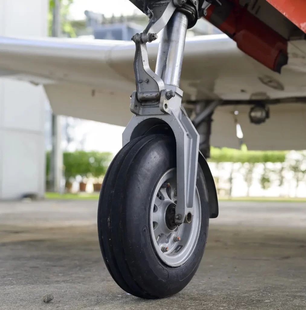 An image of the landing gear of a plane comprising a rubber wheel and steel parts