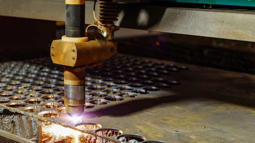 Laser cutter in action, cutting through a metal sheet for hole formation.