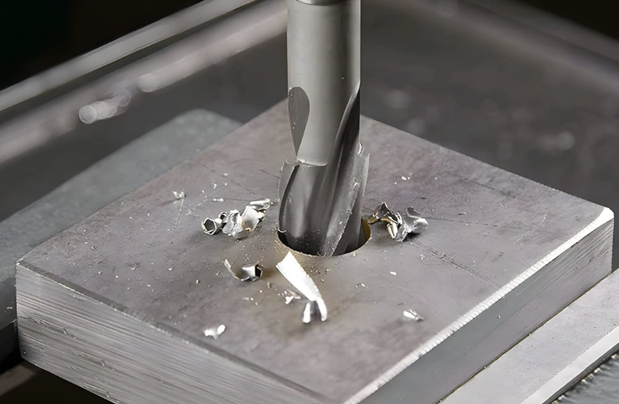 A milling tool creating a hole in a metal plate