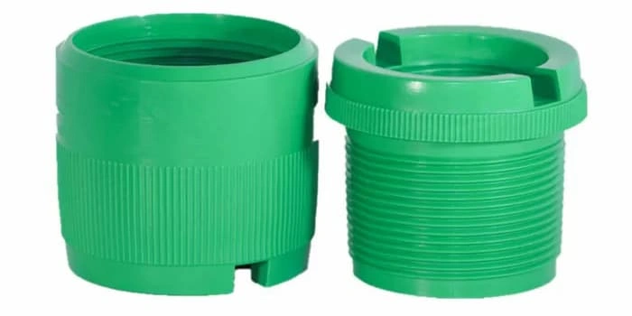 Two green-colored plastic fittings made from injection molding, external and internal threads 