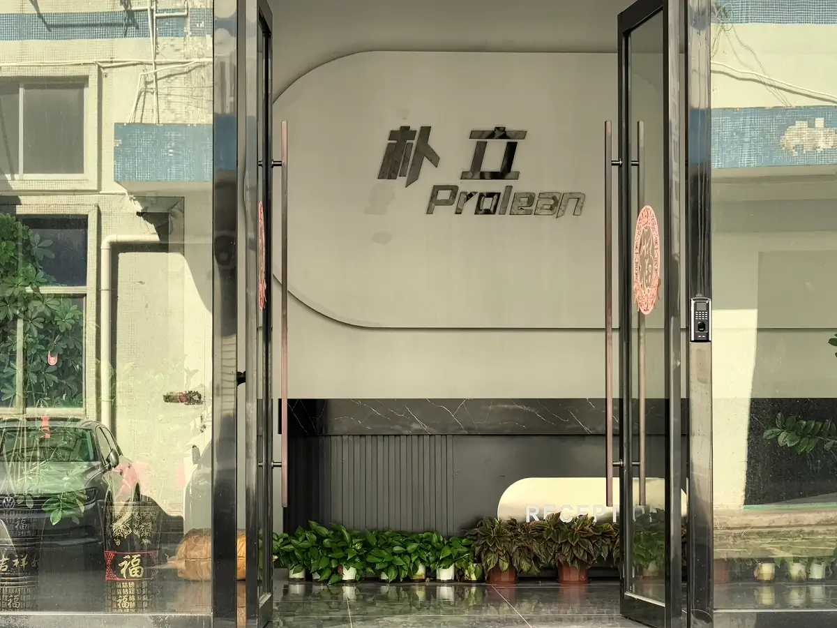 The image shows the front entrance of ProleanTech's factory, featuring a reception desk and the company's logo displayed in both Chinese and English at the forefront.