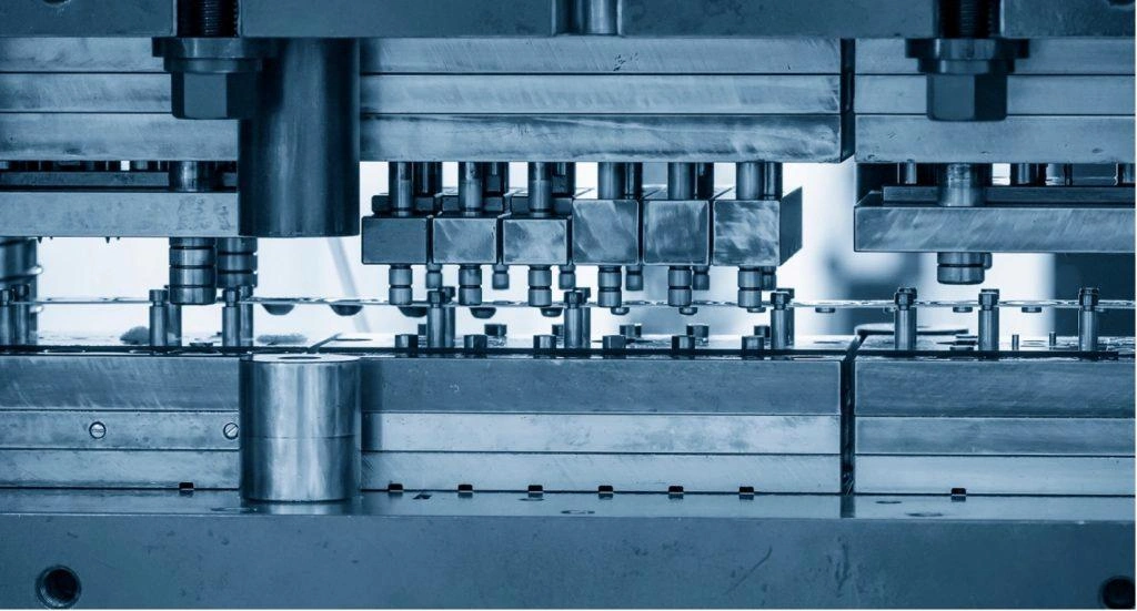 A close-up view of a progressive stamping die and punch setup clearly illustrates two halves and other components