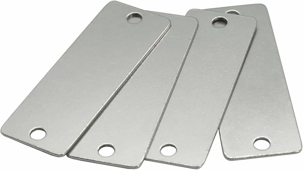 Four rectangular stainless blanks for stamping with circular holes on both ends.