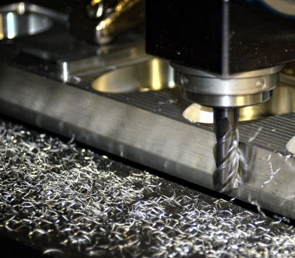 An image of a CNC milling tool removing material from the edge of a workpiece 