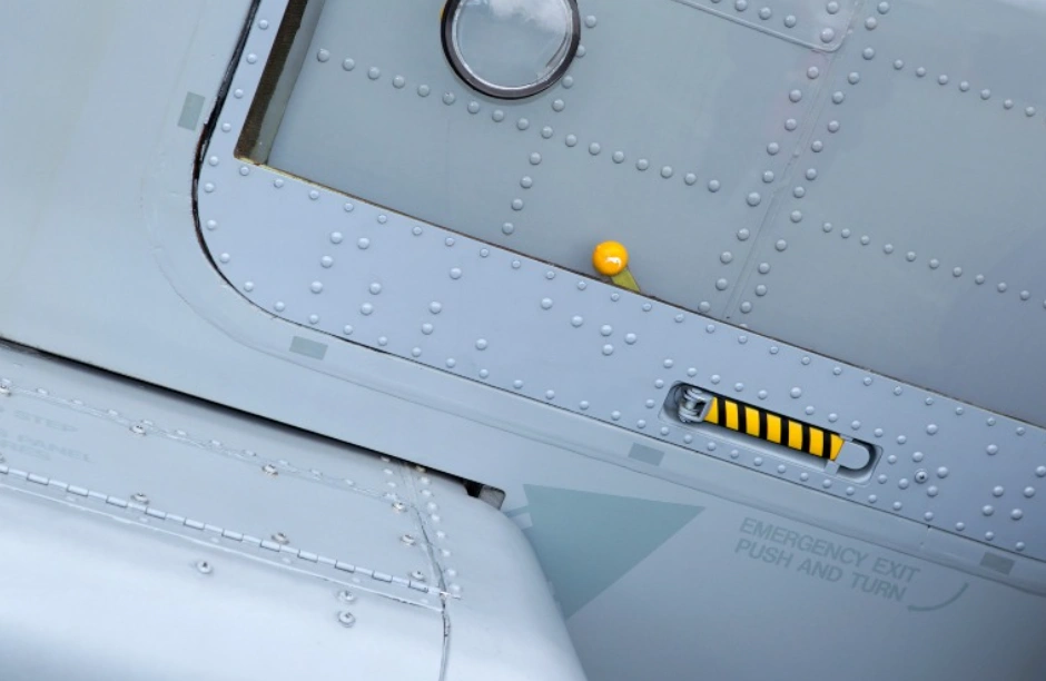 An image showing many fasteners near the emergency exit of an aircraft