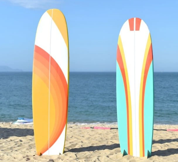 Two surfboards with beautiful decorations placed upright on a beach