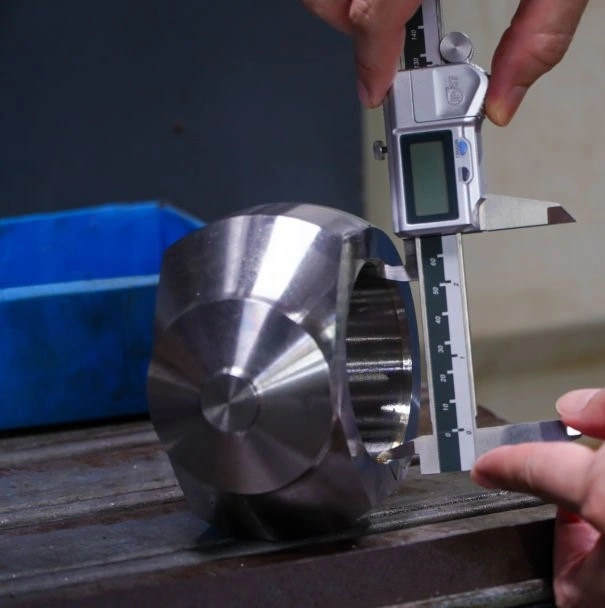 An image of a person using digital calipers to measure the diameter of a hole in a shiny metal component