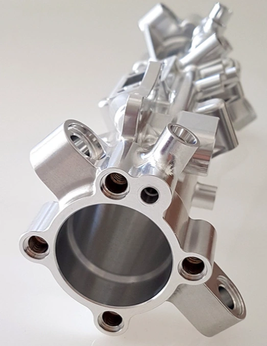 A closeup image of a bright silver CNC machined steering rack housing